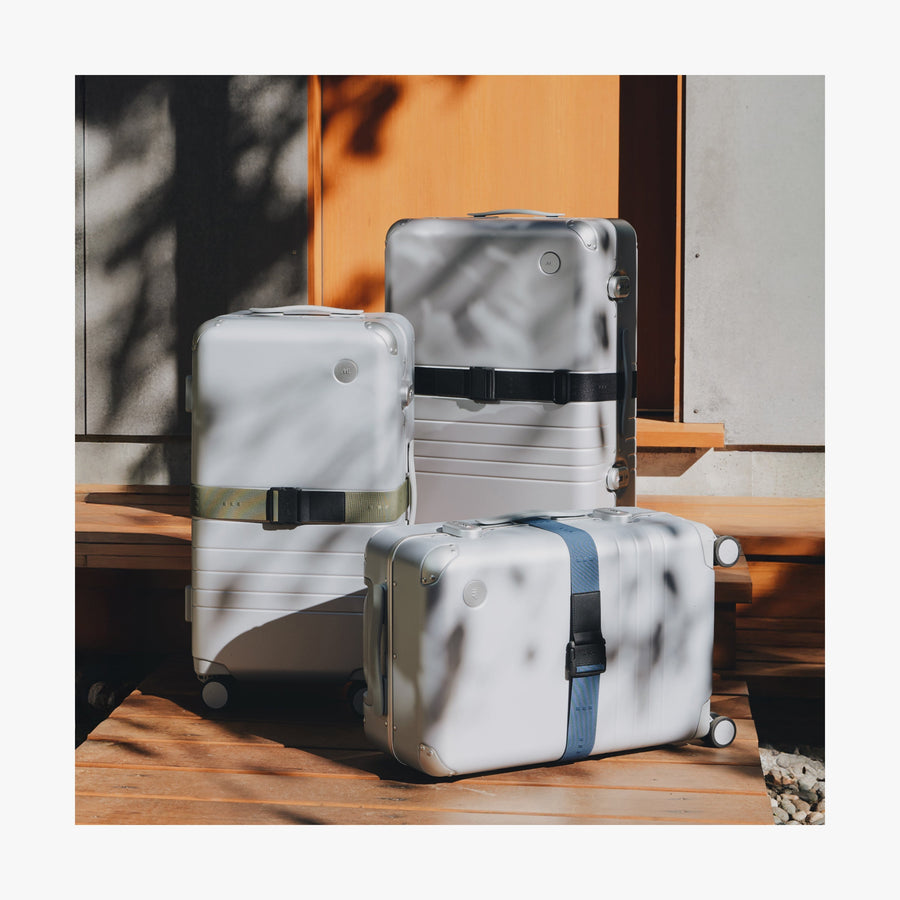 Olive Green | Front view of three Aluminum suitcases displaying all three Luggage Strap colors