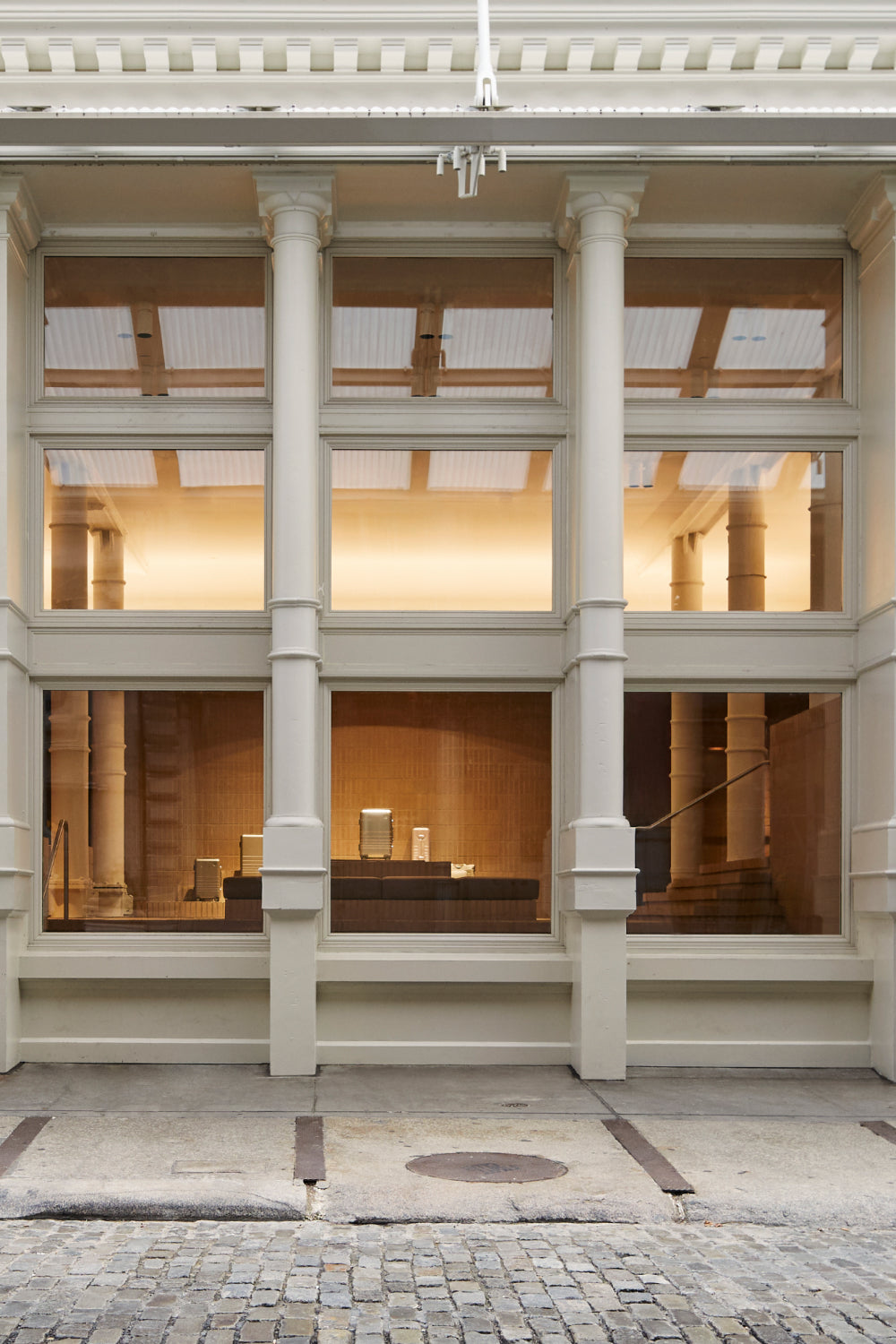 Monos SoHo store exterior in New York City with tall columns and large windows.