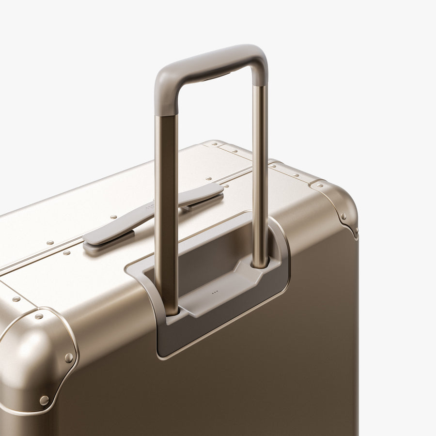 Champagne Gold | Extended luggage handle view of Aluminum Check-In Large in Champagne Gold