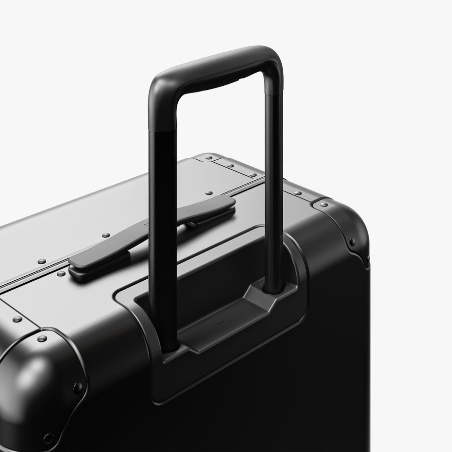 Caviar Black | Extended luggage handle view of Aluminum Check-In Medium in Caviar Black