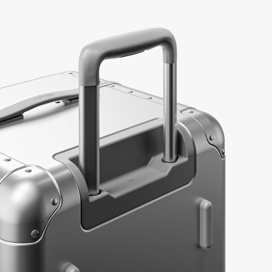 Aspen Silver | Extended luggage handle view of Aluminum Trunk in Aspen Silver