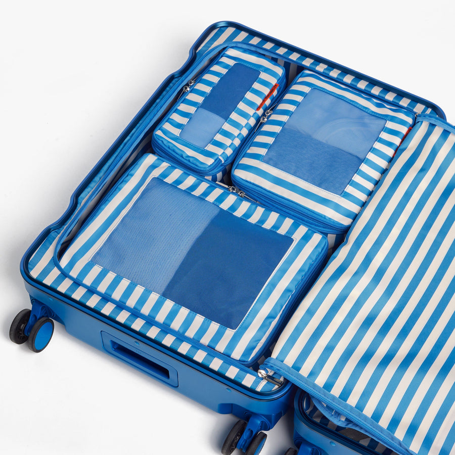Set of Six / Poplin Stripe Coastal Blue | Poplin Stripe Coastal Blue compressible packing cubes neatly organized inside a Coastal Blue suitcase