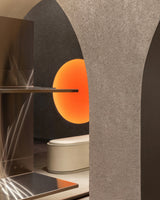 Close-up view inside the Monos Georgetown store, showing textured arches, brushed steel shelving, and a softly glowing circular light feature in warm amber tones.