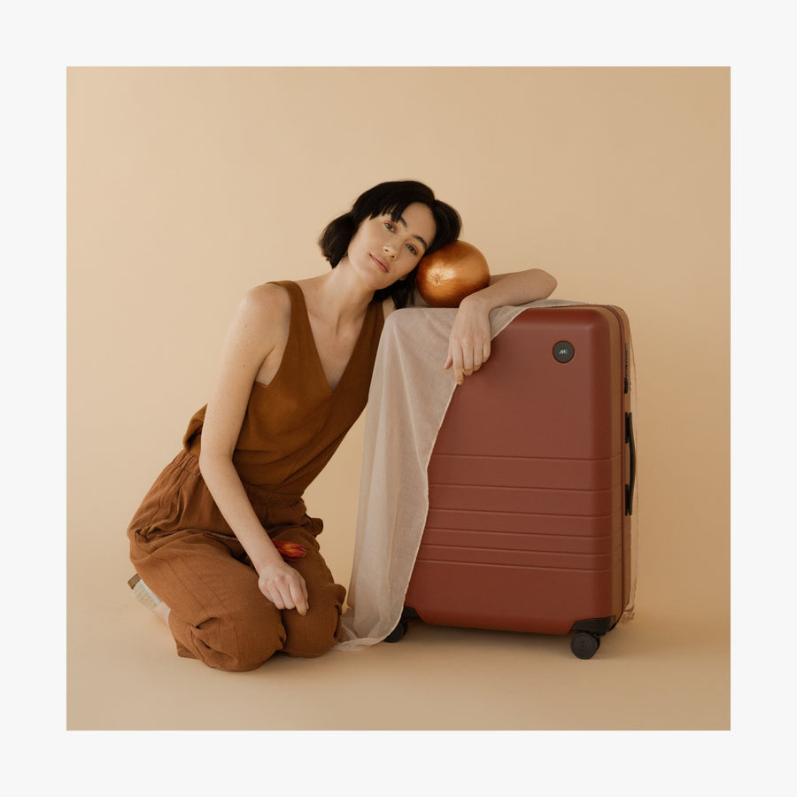Terracotta | This is a photo of a women leaning on a Terracotta Carry-On Plus