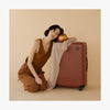 This is a photo of a women leaning on a Terracotta Carry-On Plus (thumbnail)